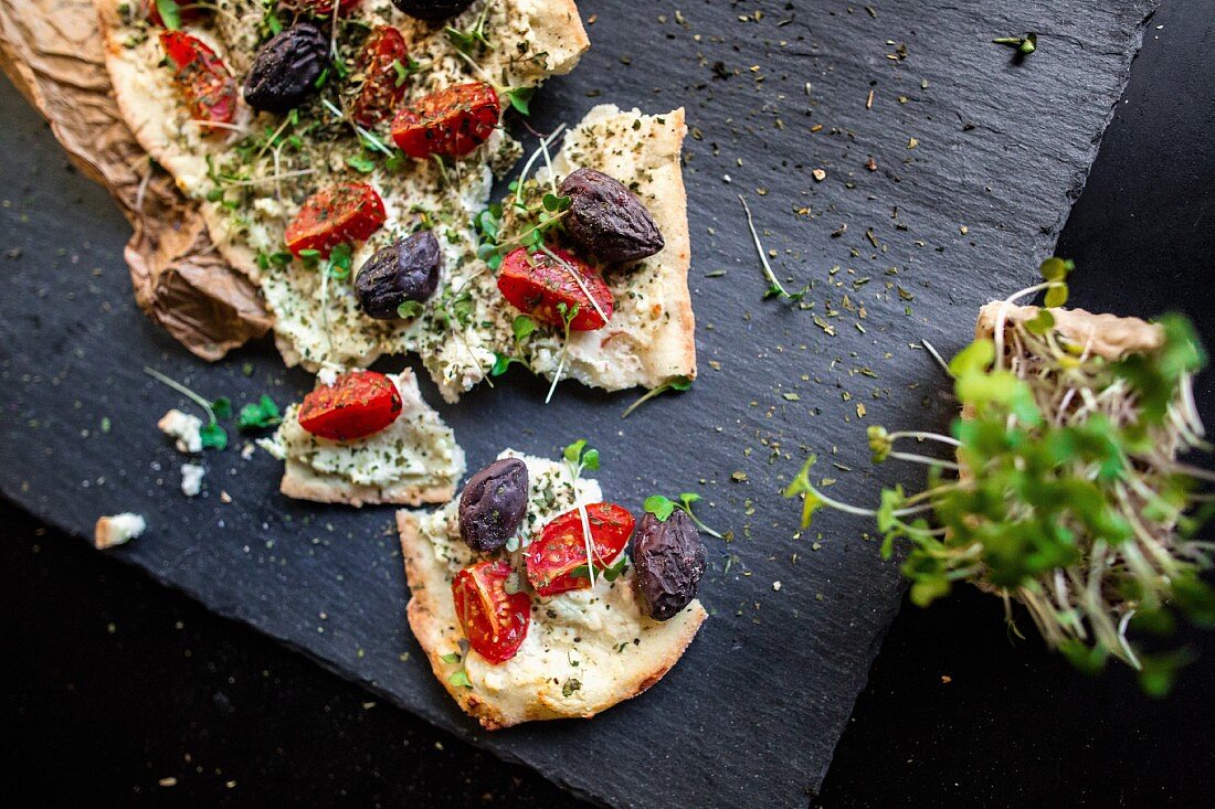 Unleavened bread with tomatoes, olives and fresh cress
