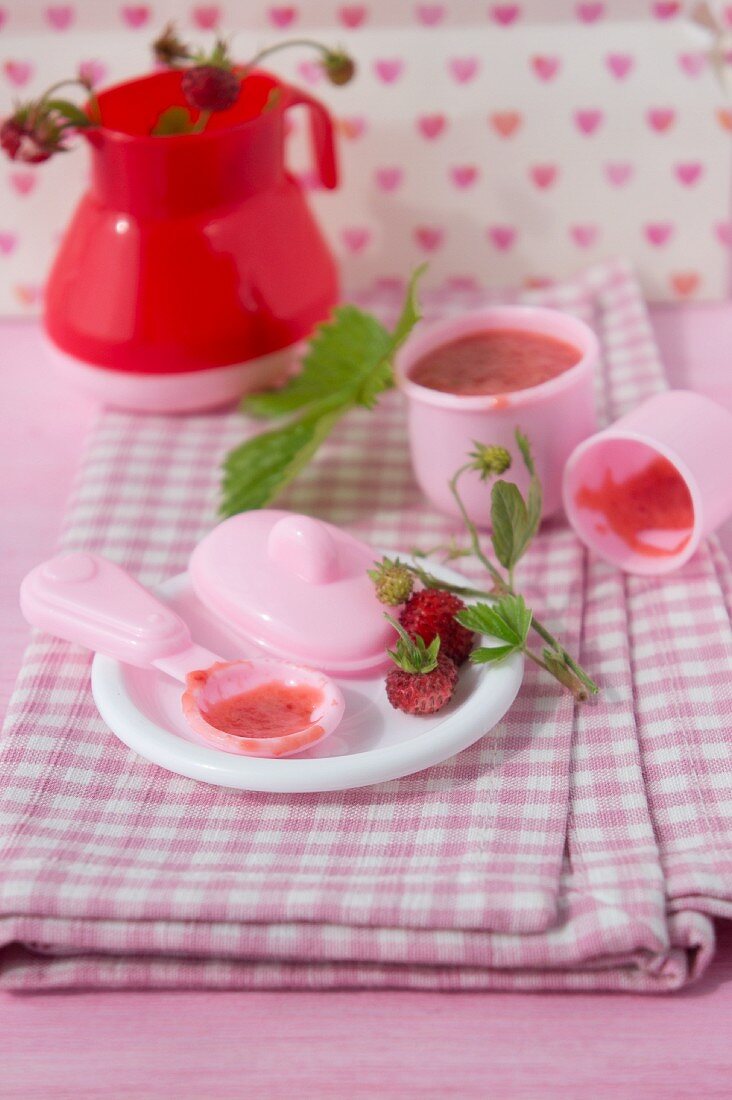 Wild strawberries with sugar and condensed milk served on a dolls' tea set