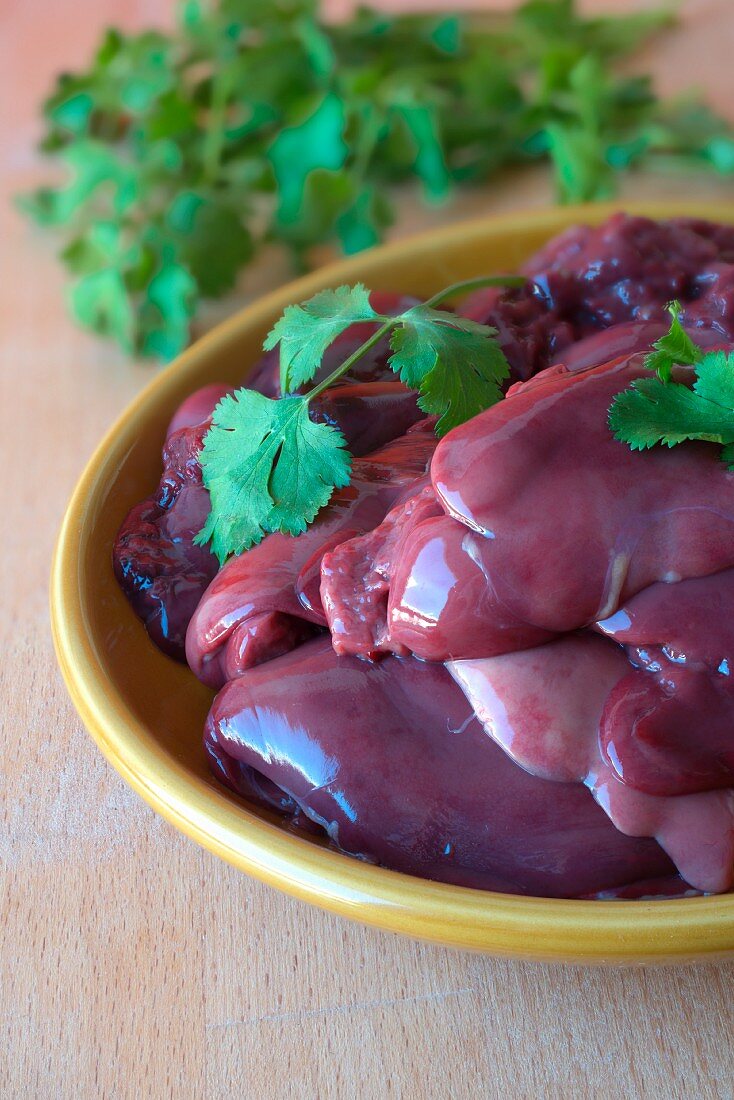 Chicken liver with coriander leaves in a ceramic bowl