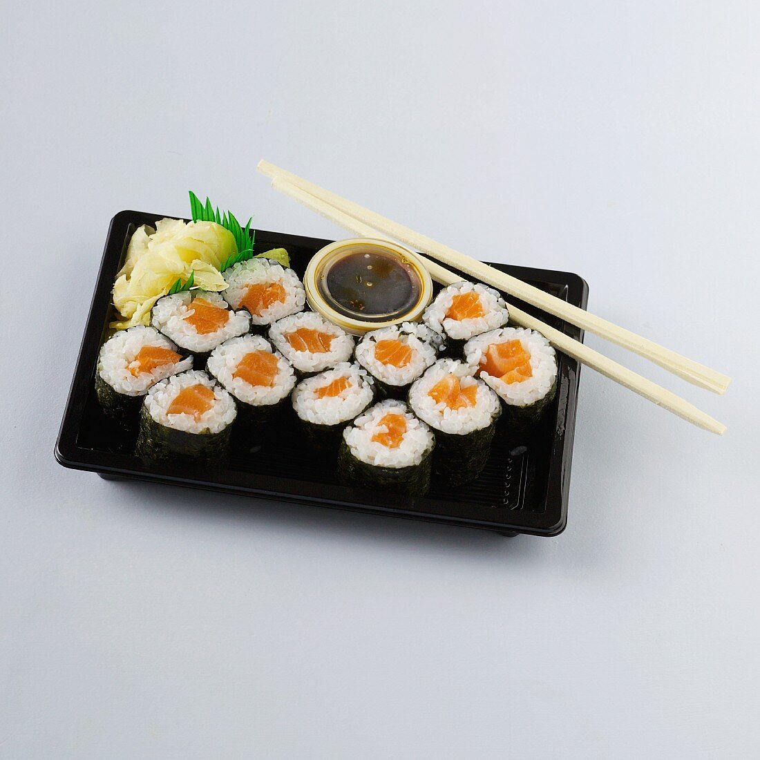 Maki sushi with salmon, soy sauce and ginger