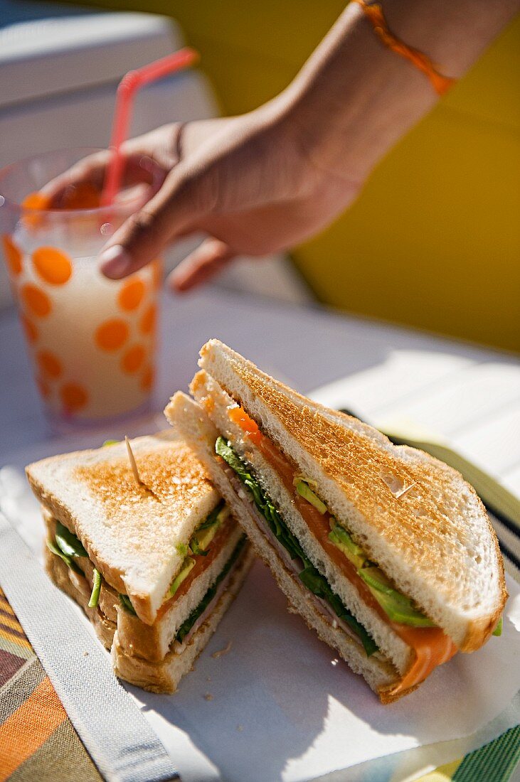 Sandwich mit Lachs, Salat und Avocado; dazu eine selbstgemachte Limonade
