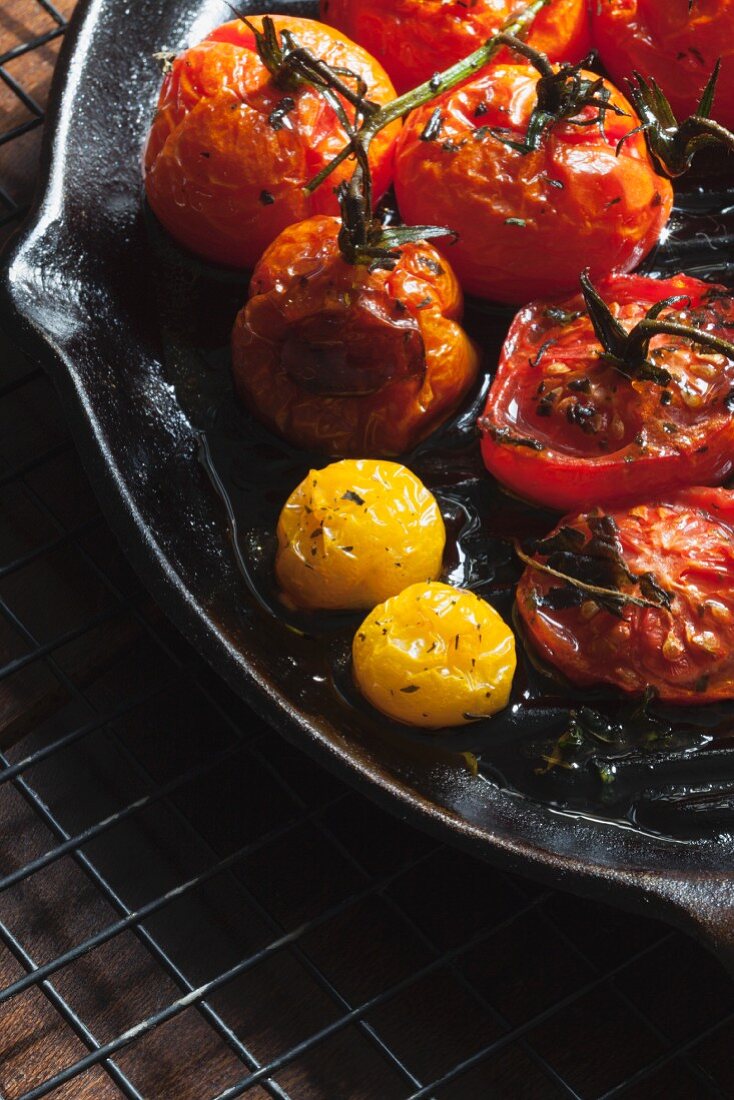 Gebratene rote und gelbe Tomaten in Gusseisenpfanne