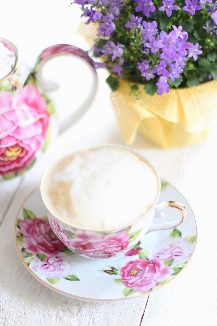 Cappuccino in einer Tasse mit Rosenmuster