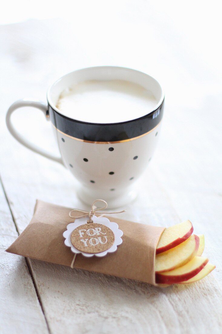 A cup of cafe au lait and fresh apple slices