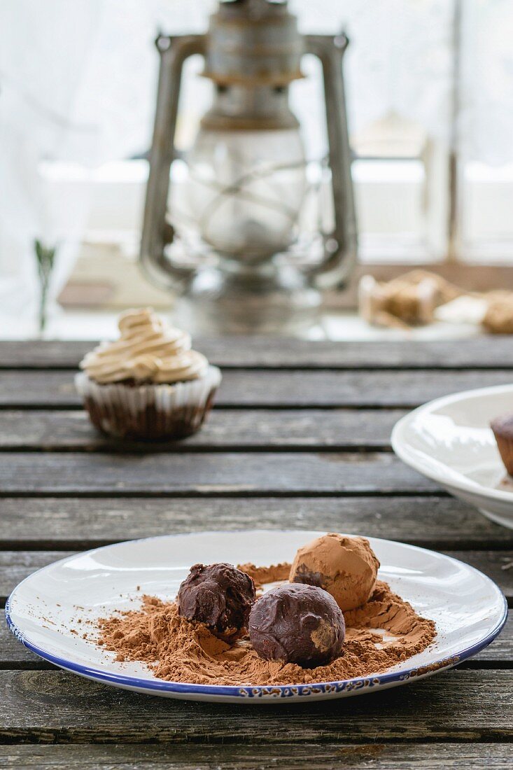 Homemade chocolate truffles on an old wooden table in front of a window