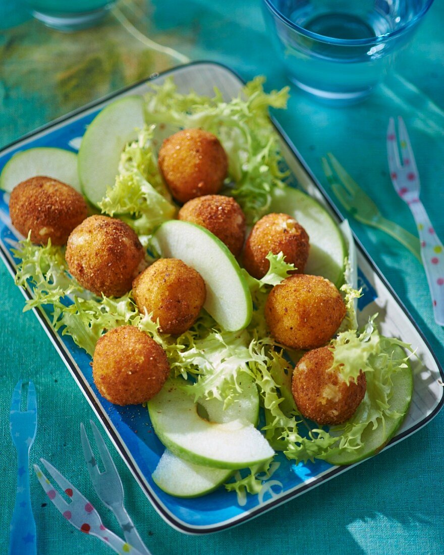 Breaded cheese balls with apple wedges and lettuce