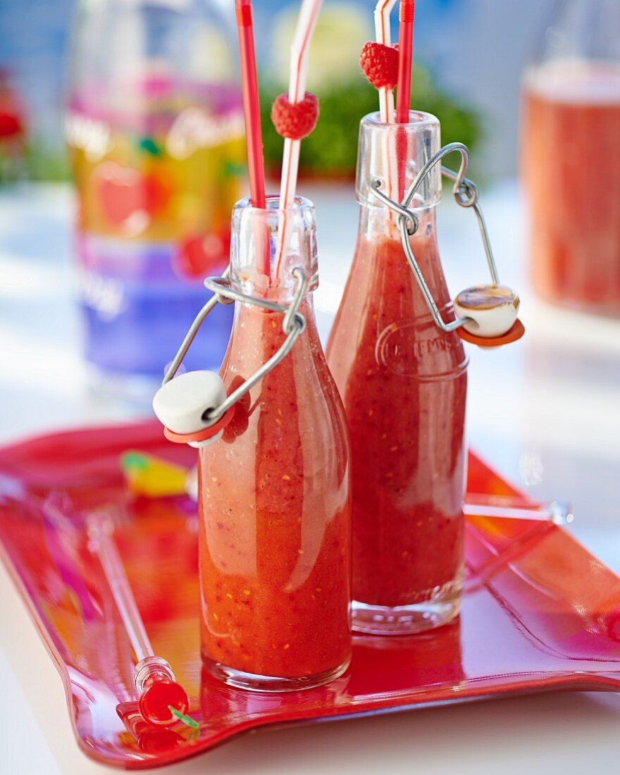 Selbstgemachte Pfirsich-Himbeer-Smoothies in Glasflaschen