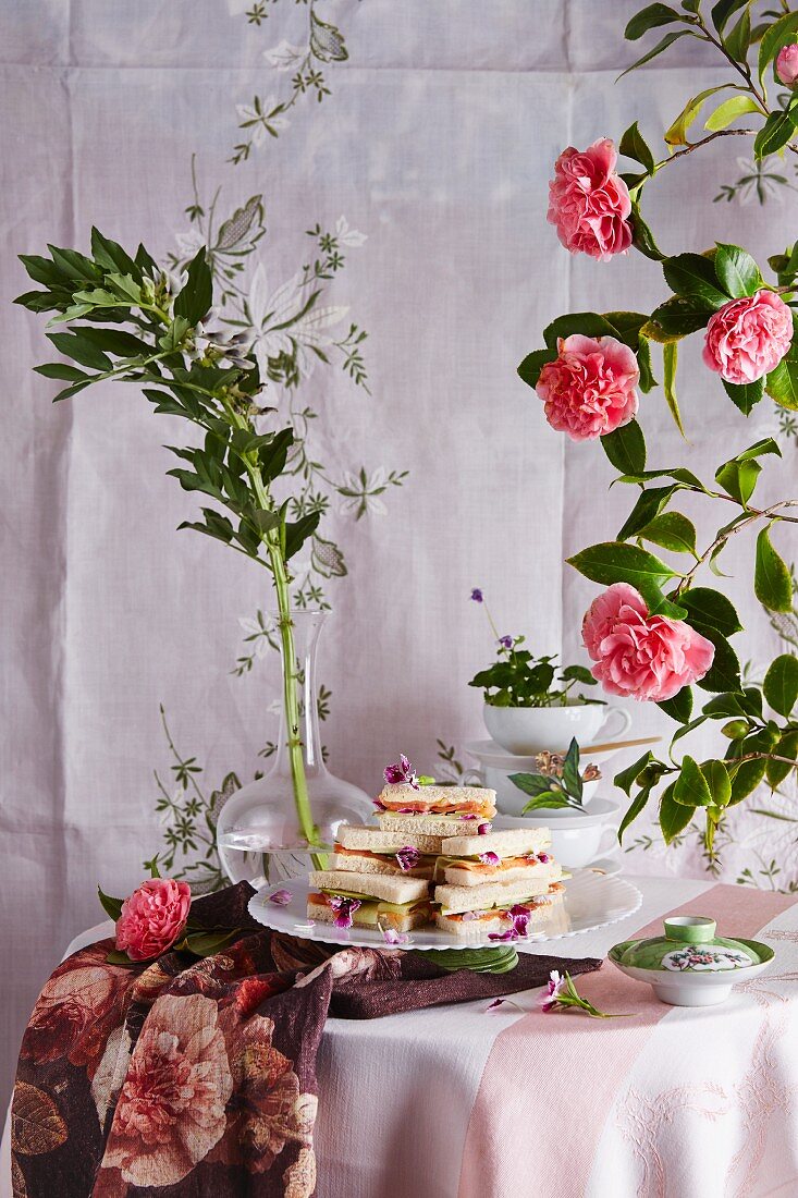 Classic tea time sandwiches with smoked trout, cucumber, apple and organic carnations