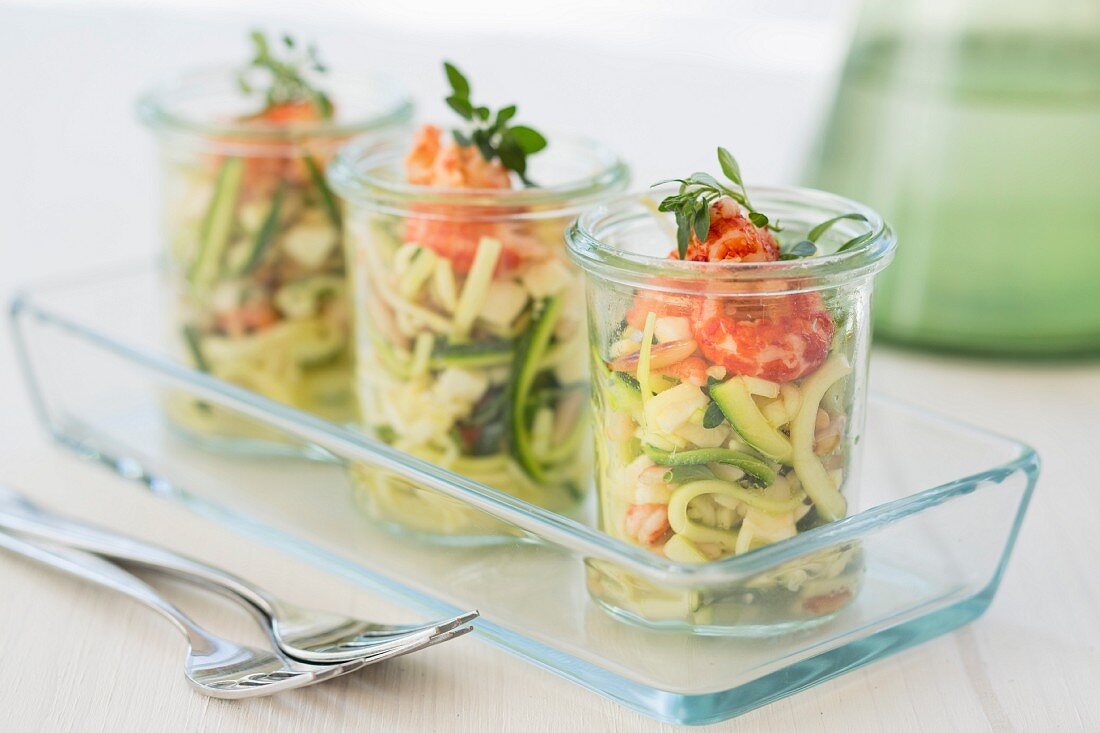 Three glasses of courgette salad with crayfish, mozzarella, oregano and pine nuts