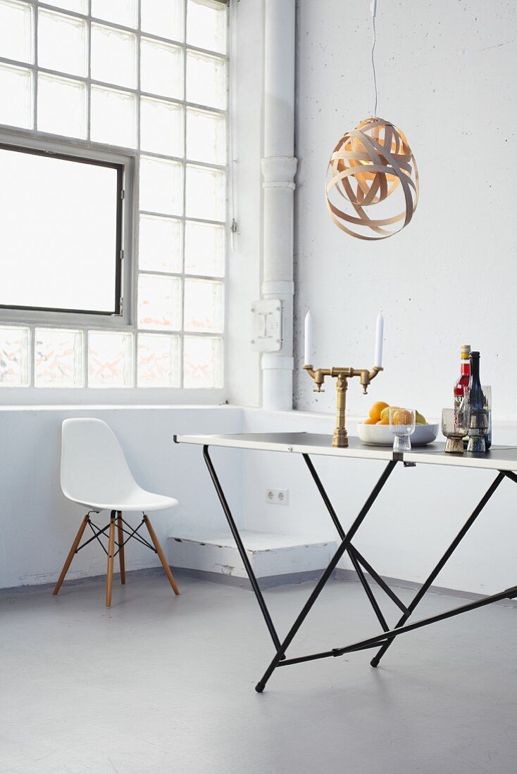 DIY lampshade made from strips of wood veneer above trestle dining table