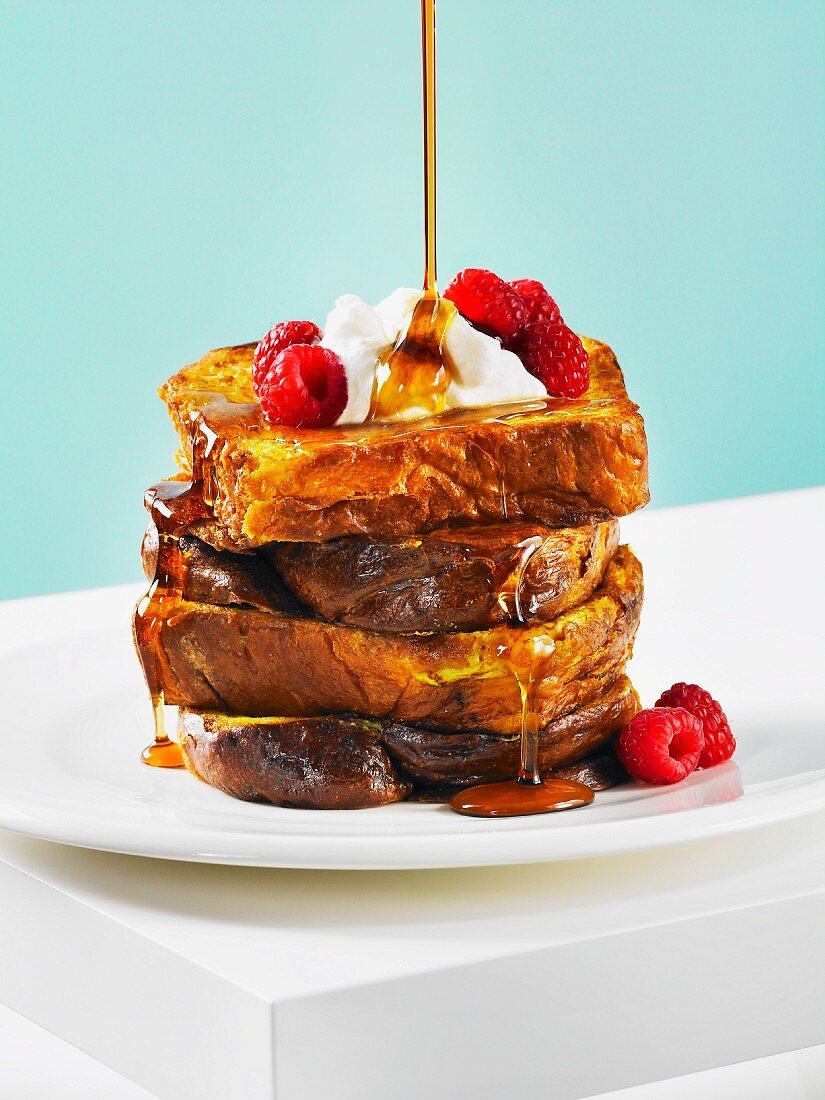 French toast with maple syrup, whipped cream and raspberries