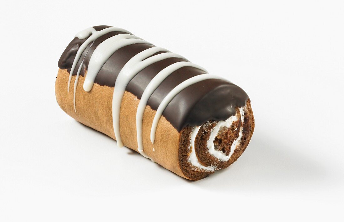 A chocolate Swiss roll with cream and icing sugar