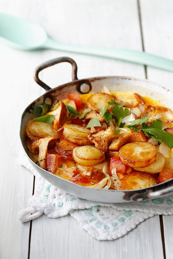 Fried potatoes with fresh chanterelle mushrooms, tomatoes and eggs