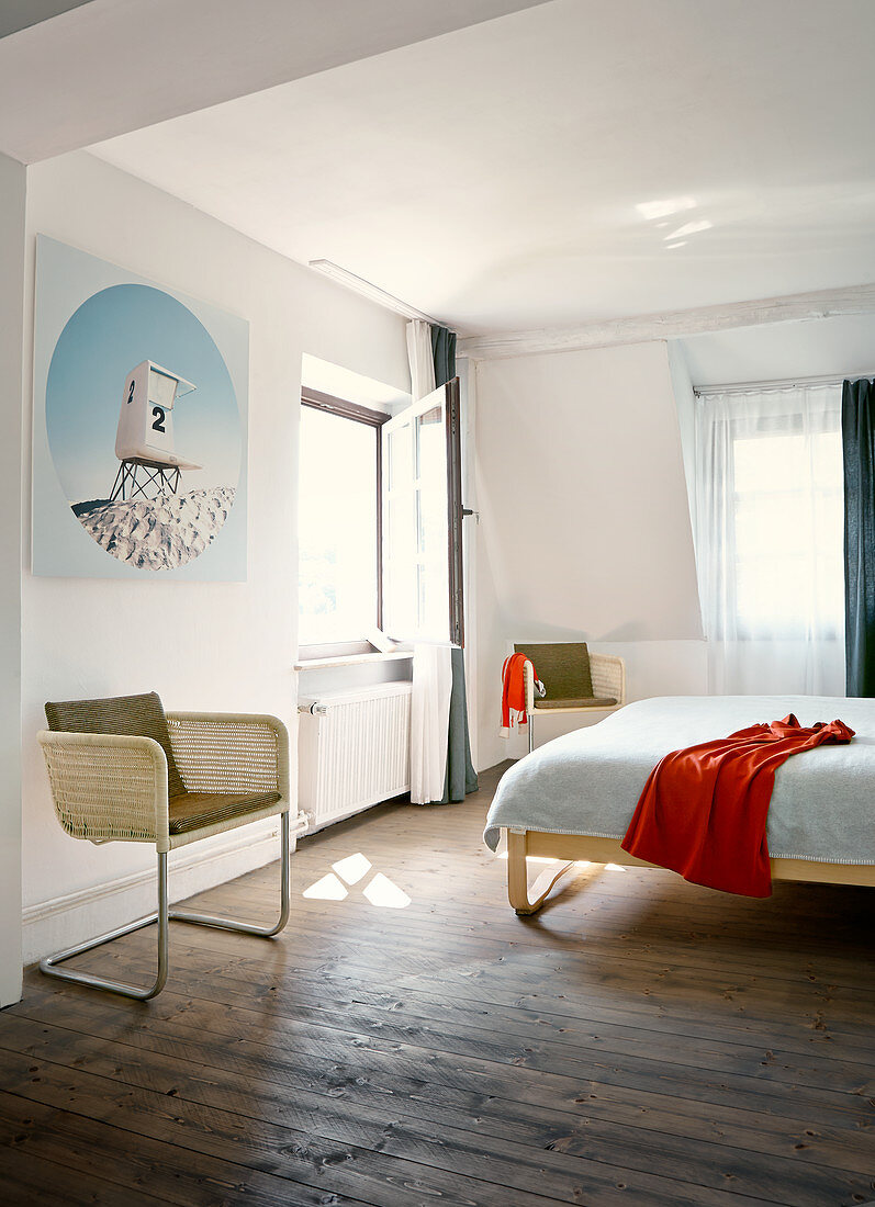 Pale, cane cantilever chairs in simple bedroom with rustic wooden floor