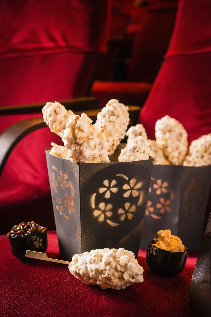 Schoko-Marshmallow-Popcorn-Spiesse in Tüten auf einem Kinosessel