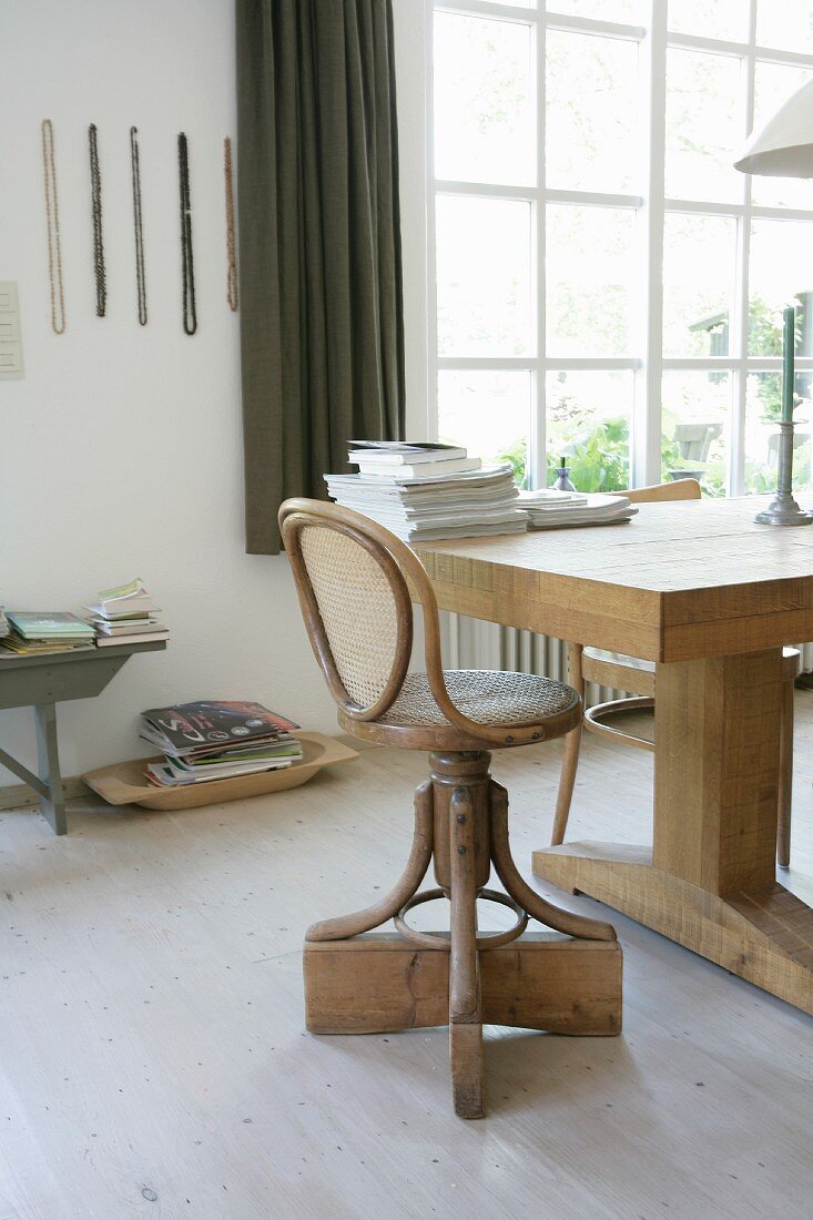 Vintage swivel chair with bentwood frame at rustic, solid-wood table