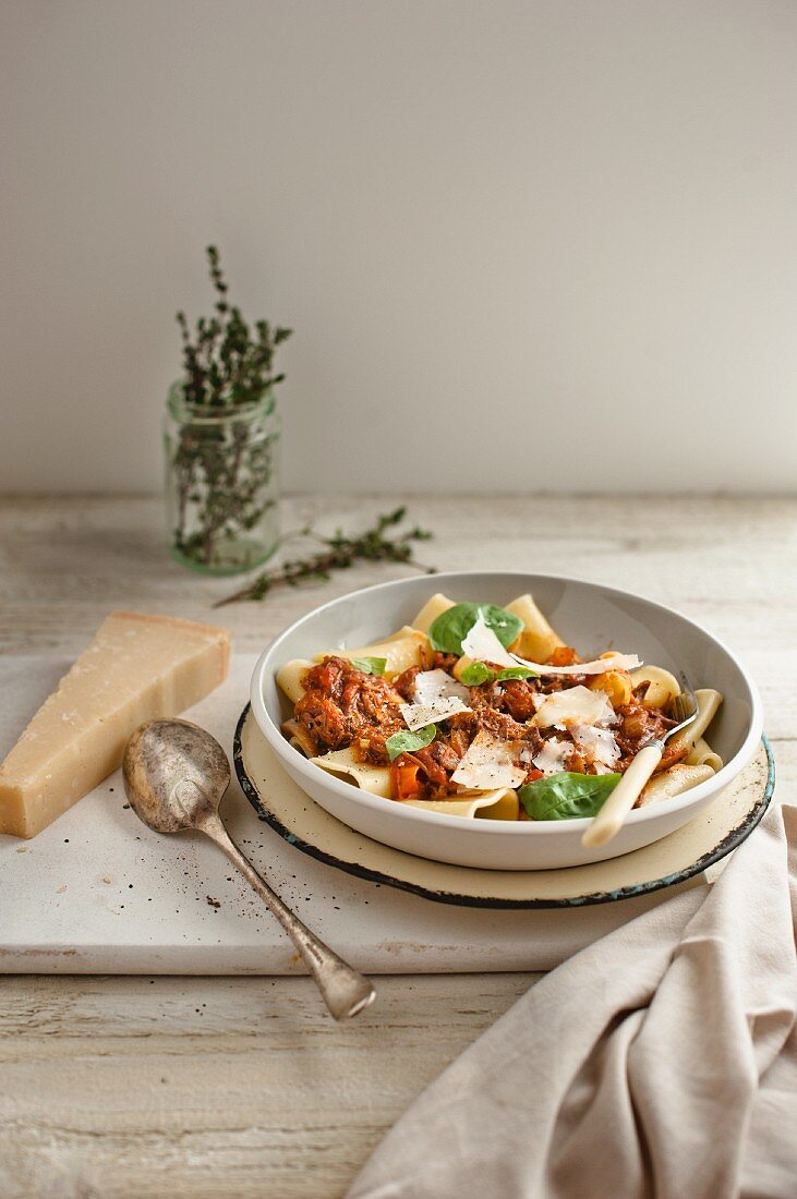 Pasta with beef ragout, Parmesan cheese and basil
