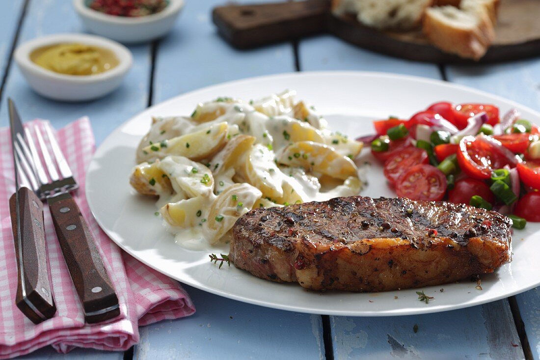 Rump steak with potato salad and tomato salad