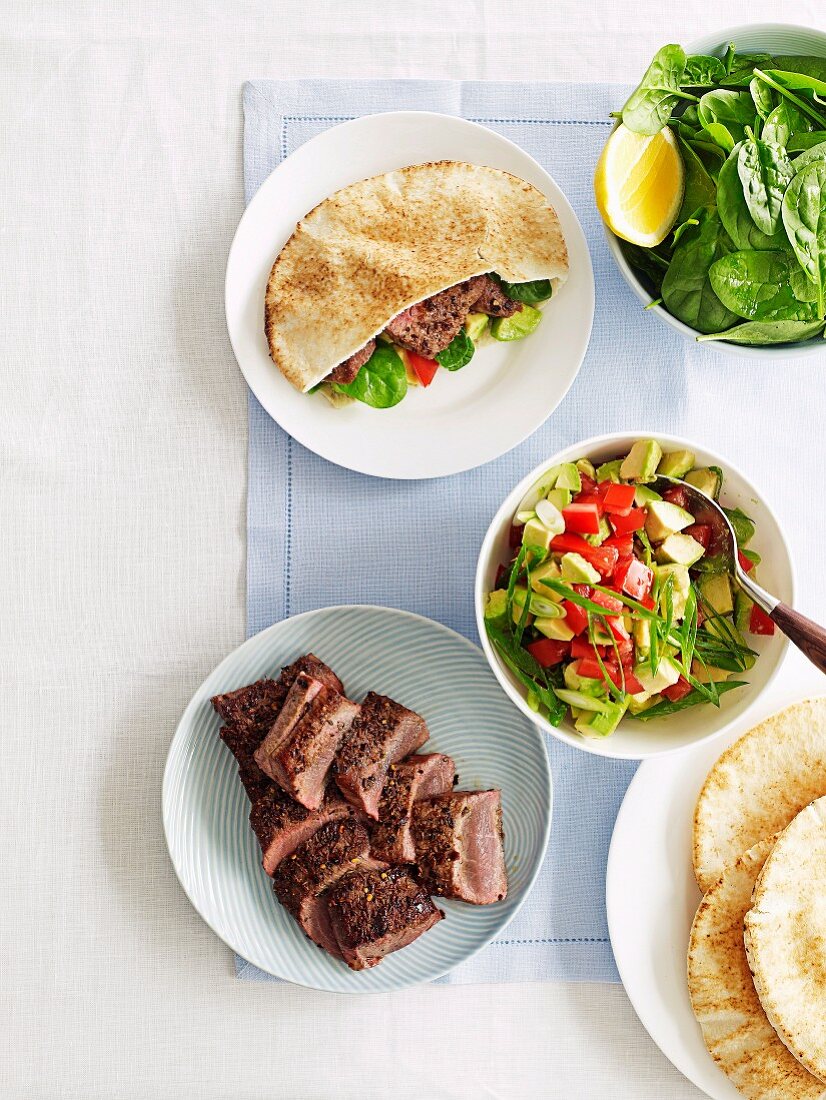 Spicy lamb pitas with avocado salad and spinach