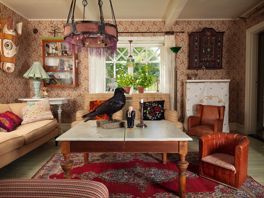 Coffee table with wooden base, child's brown leather armchair and sofa on Oriental rug in rustic living room