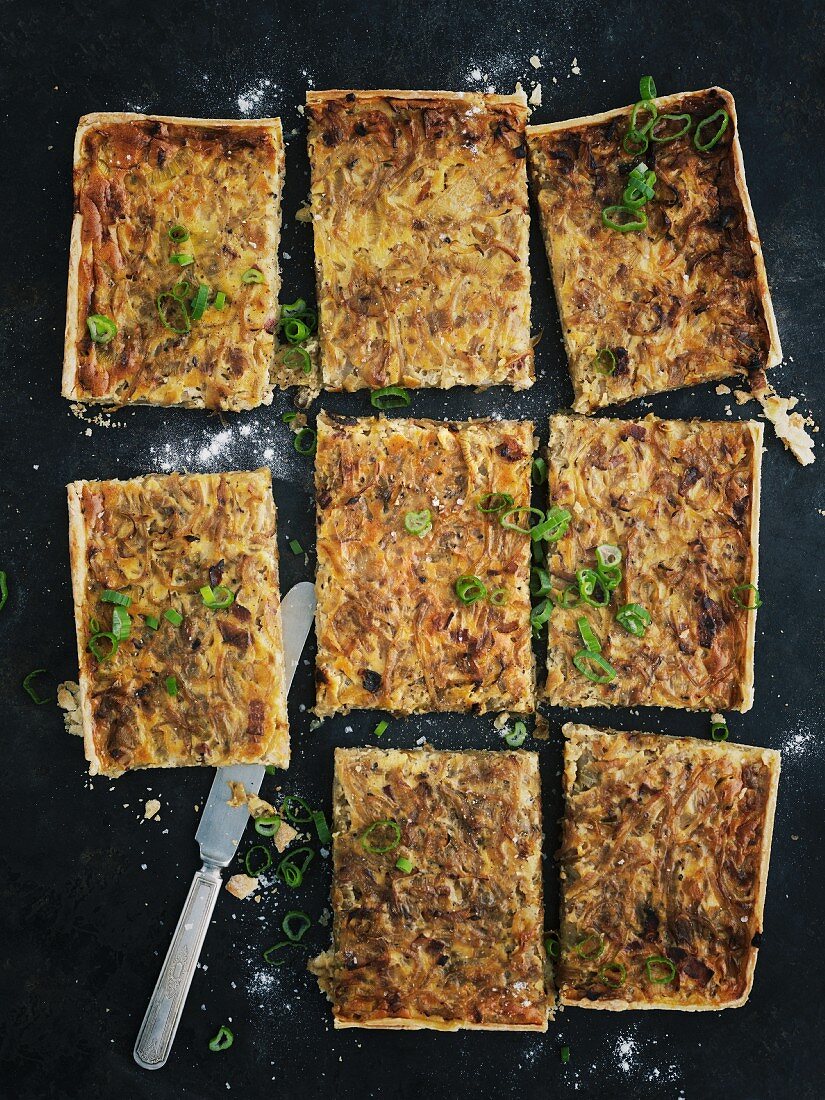 Onion cake with a knife on a baking tray