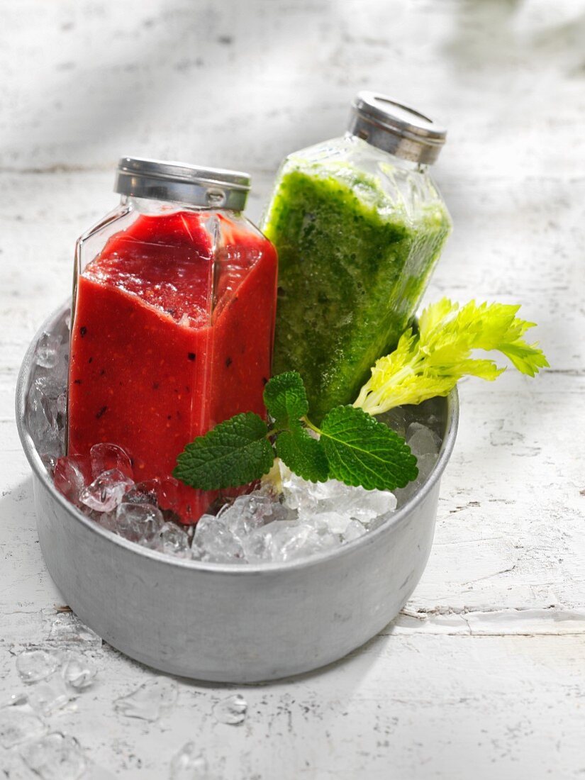 Two different smoothies in a bucket of ice