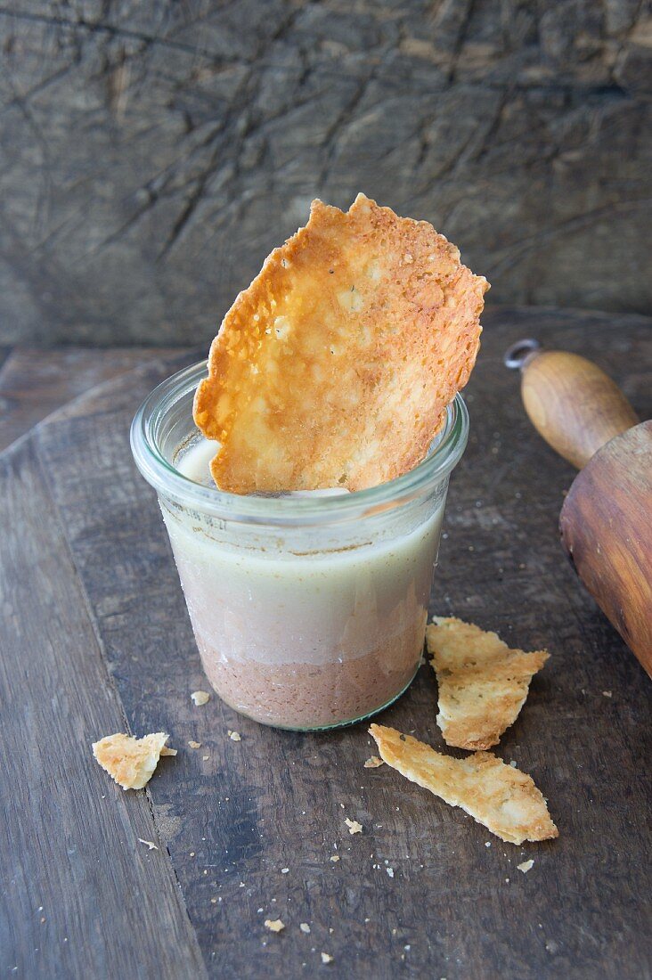 A cheese cracker with liver pâté in a glass