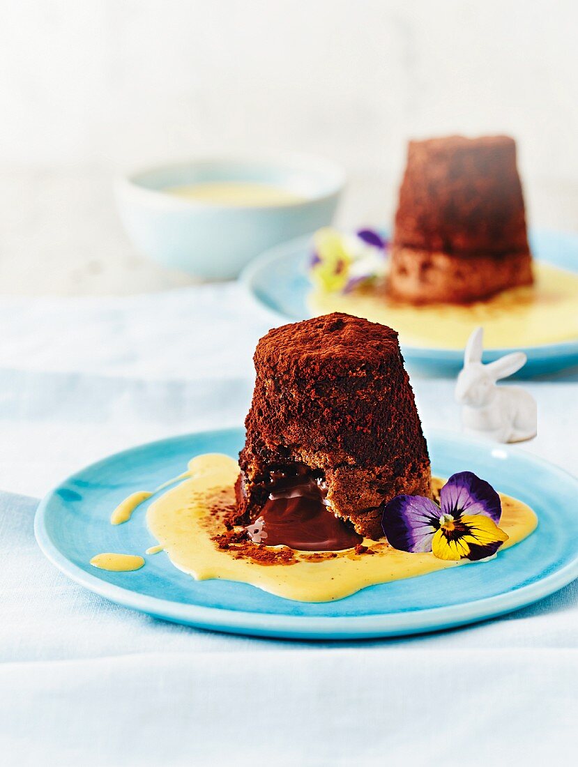 Chocolate cakes with a liquid centre served in pools of vanilla sauce