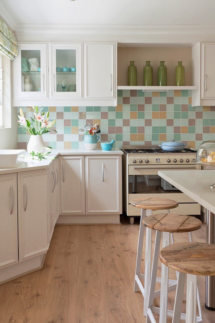 White fitted kitchen with mosaic splashback, retro cooker, breakfast bar & bar stools