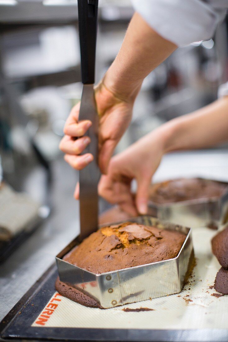 A cake being removed from a baking tin