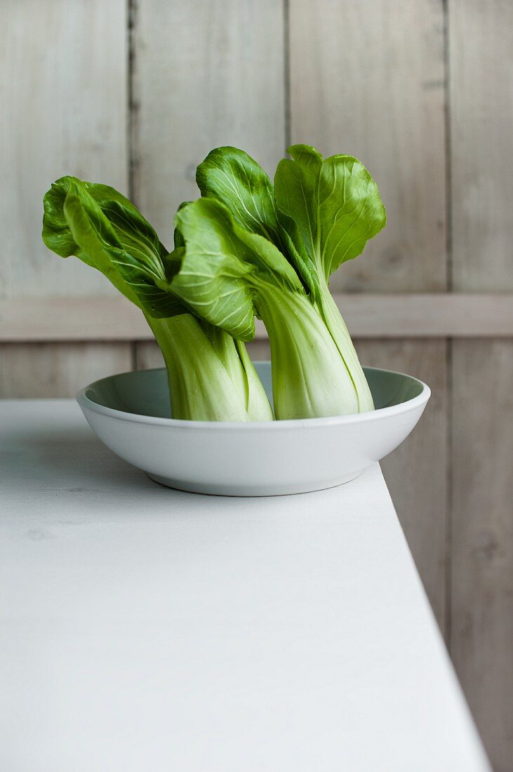 Two bok choys in a ceramic bowl
