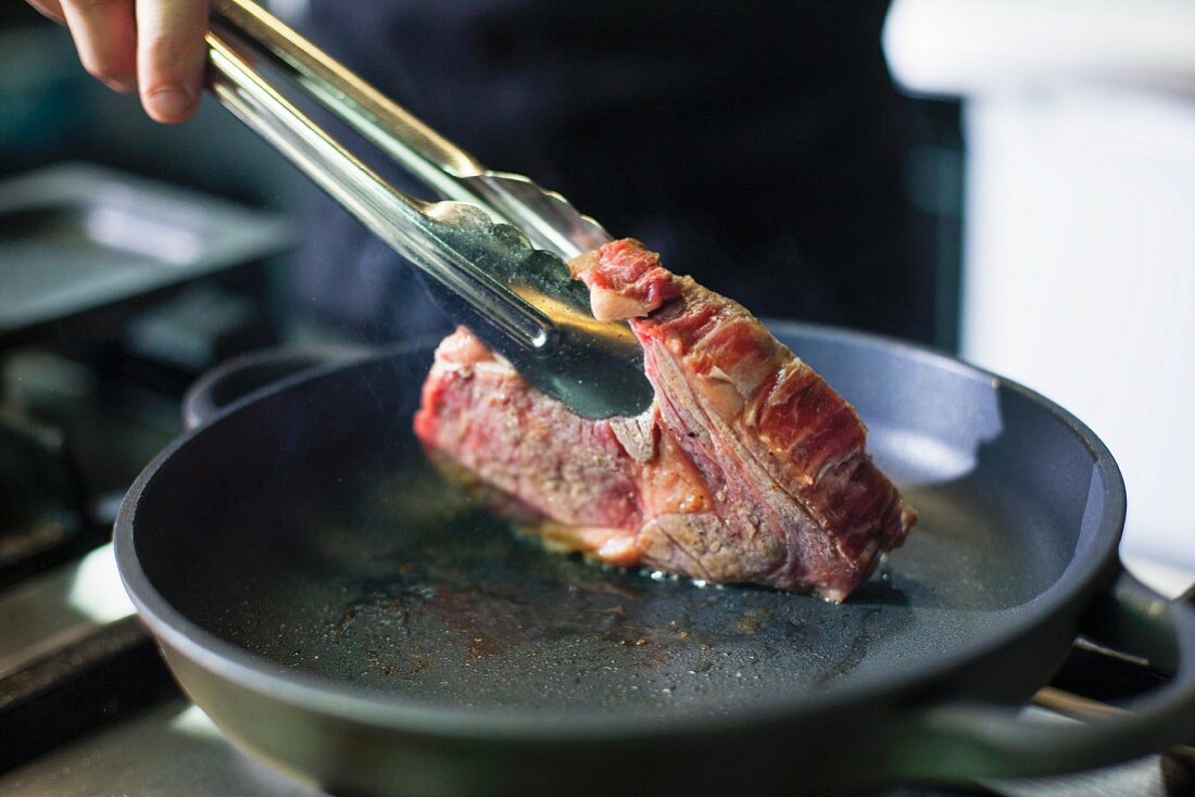 Koch bereitet Steak in der Grossküche zu