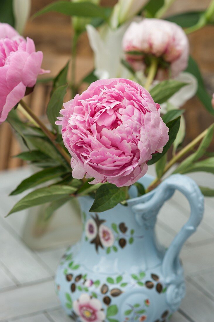 A pink peony in a painted porcelain vase