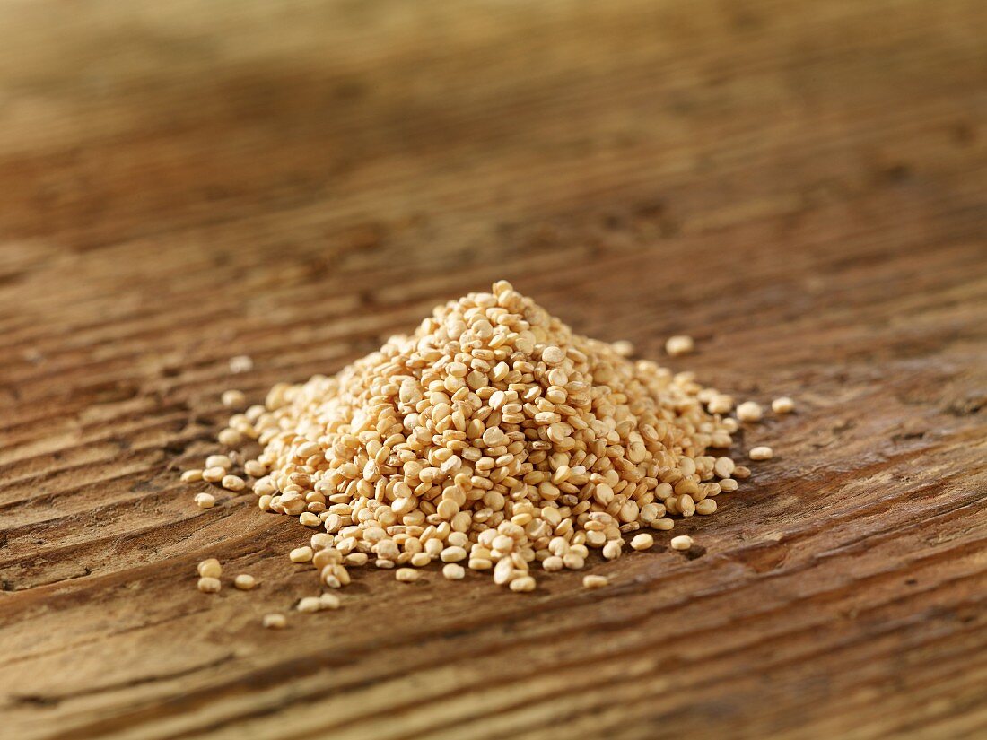 A pile of quinoa on a wooden surface