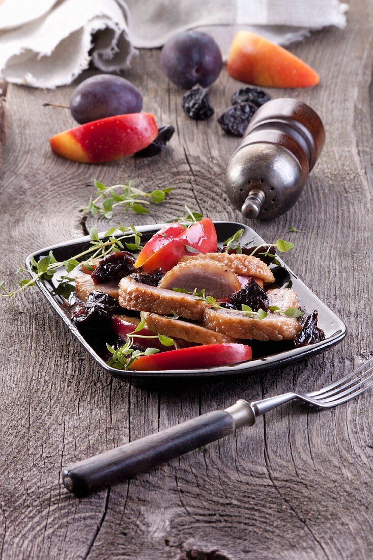 Baked goose breast with plums and apples