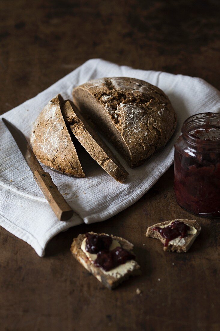 Sauerteigbrot mit hausgemachter Marmelade auf rustikalem Holzuntergrund