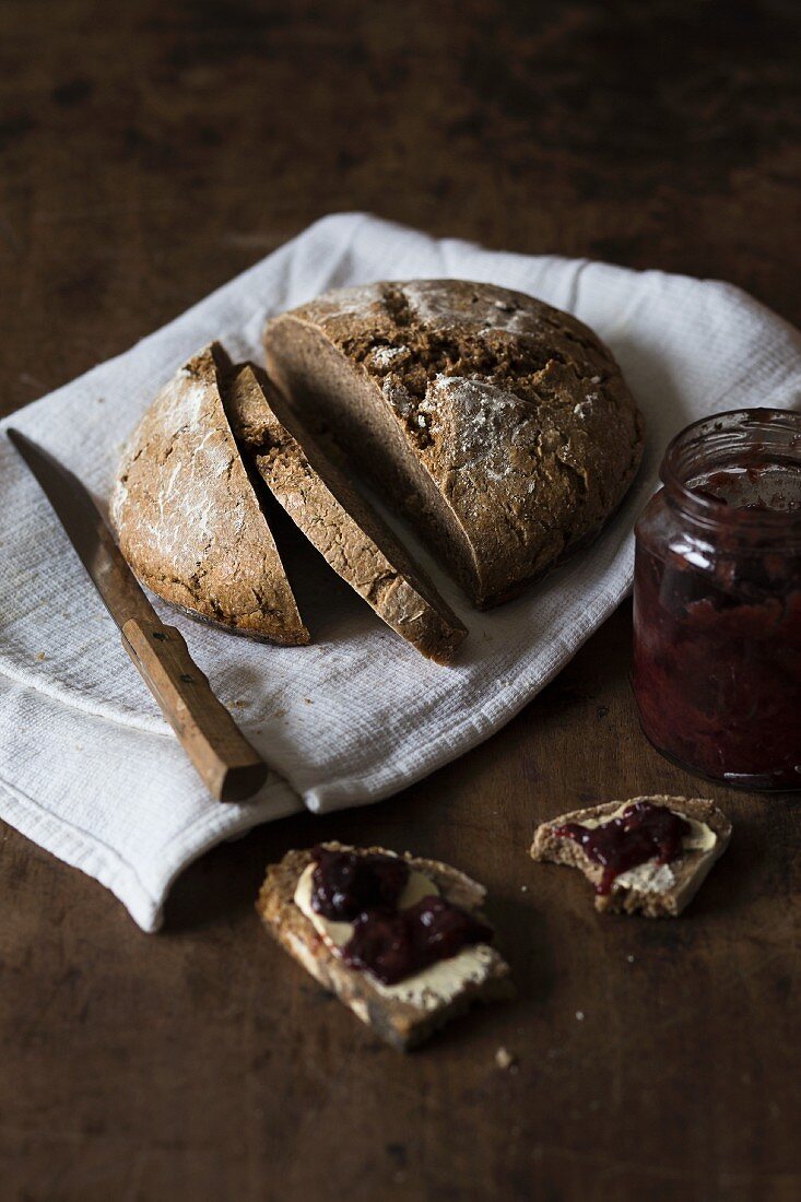 Sourdough bread with homemade jam on a rustic wooden surface
