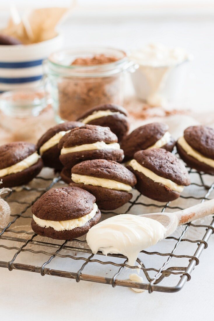 Chocolate whoopie pies filled with cream on a wire rack