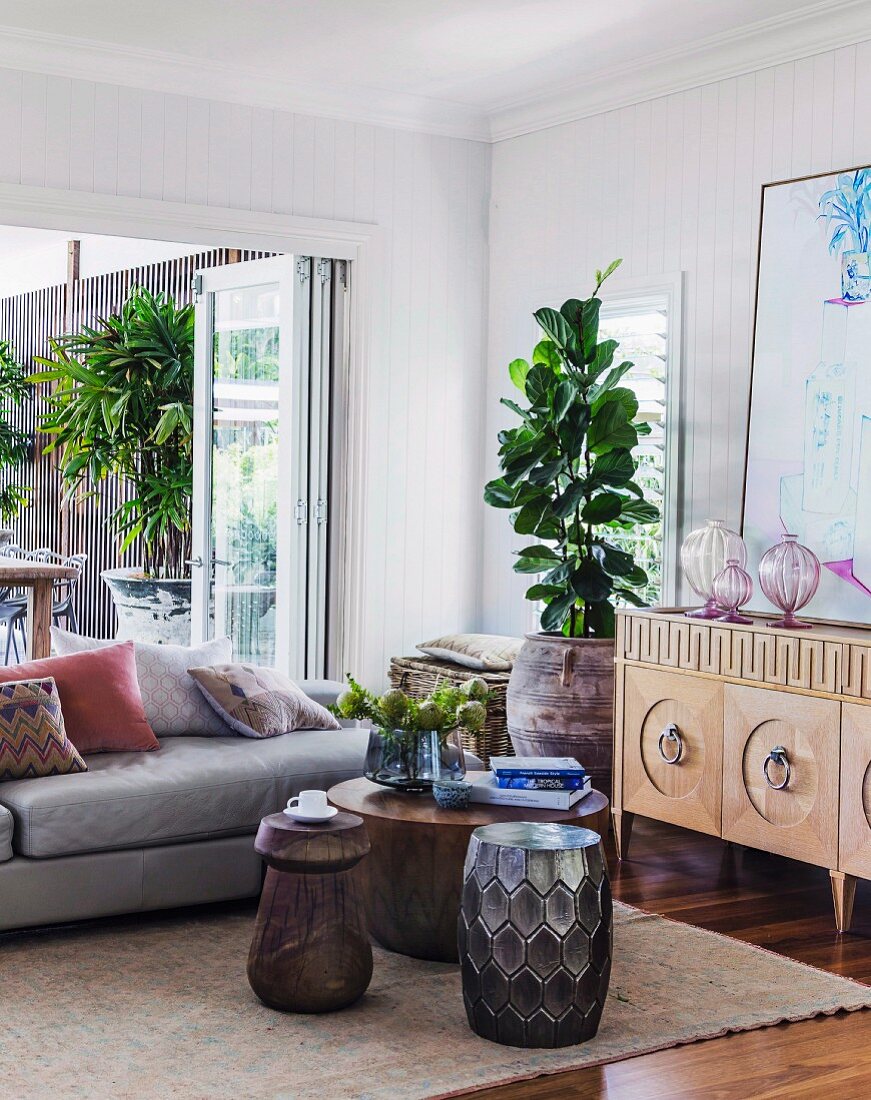 Drum-shaped side tables and ethnic-style cabinet next to modern sofa