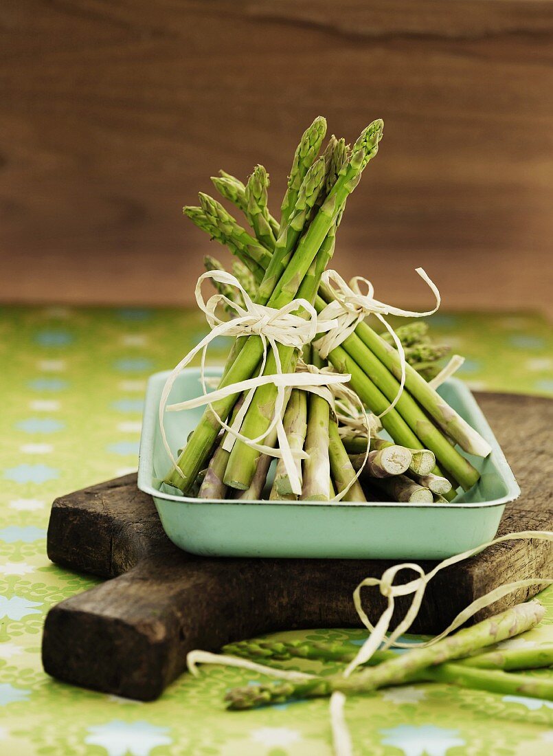 A bundle of fresh asparagus in a roasting tin