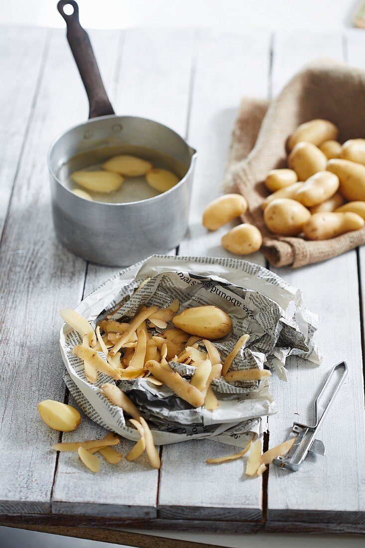 Potatoes, some partially peeled and some in a pot of water