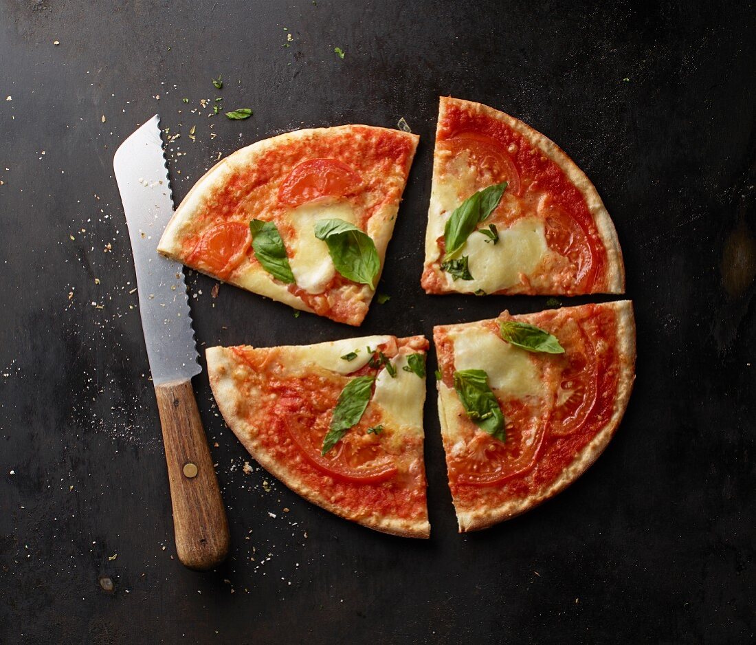 Pizza mit Tomaten, Mozzarella und Basilikum, angeschnitten