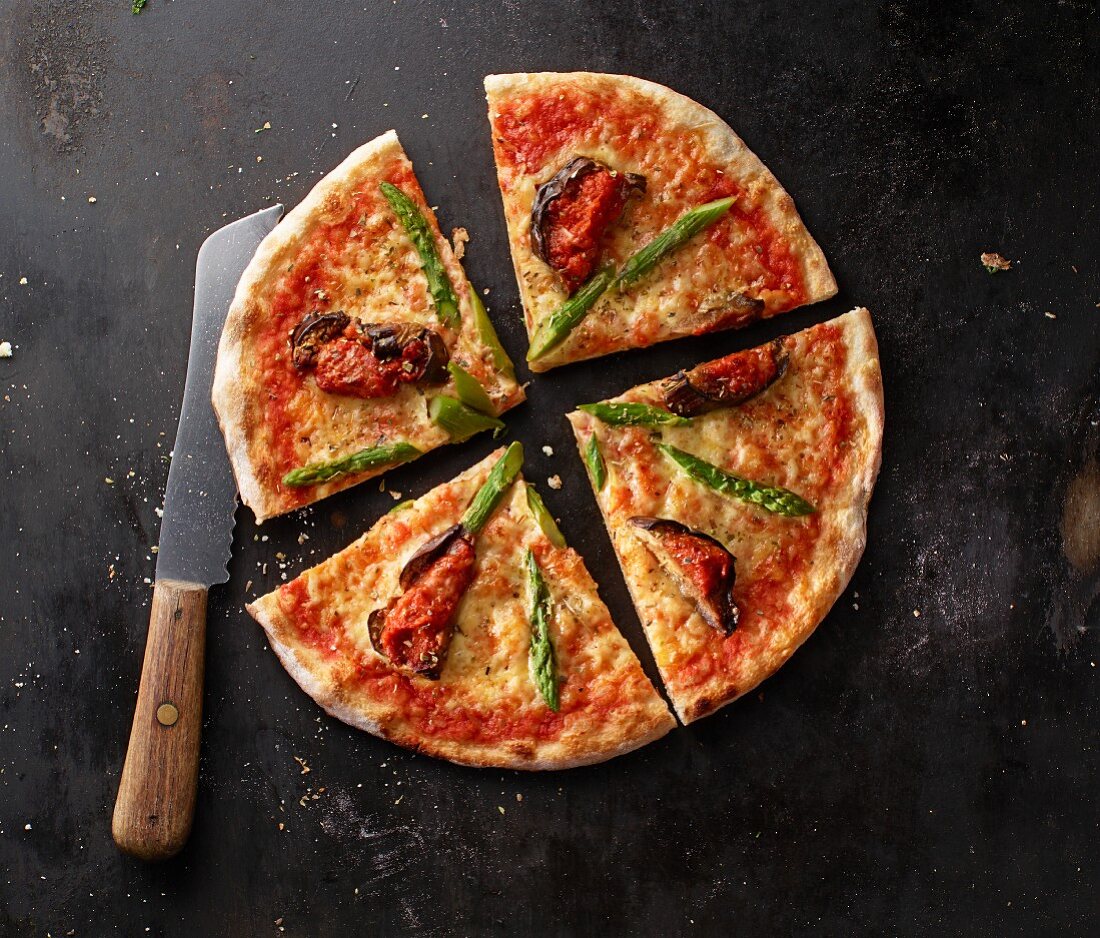Pizza Margherita with asparagus and aubergines on a baking tray