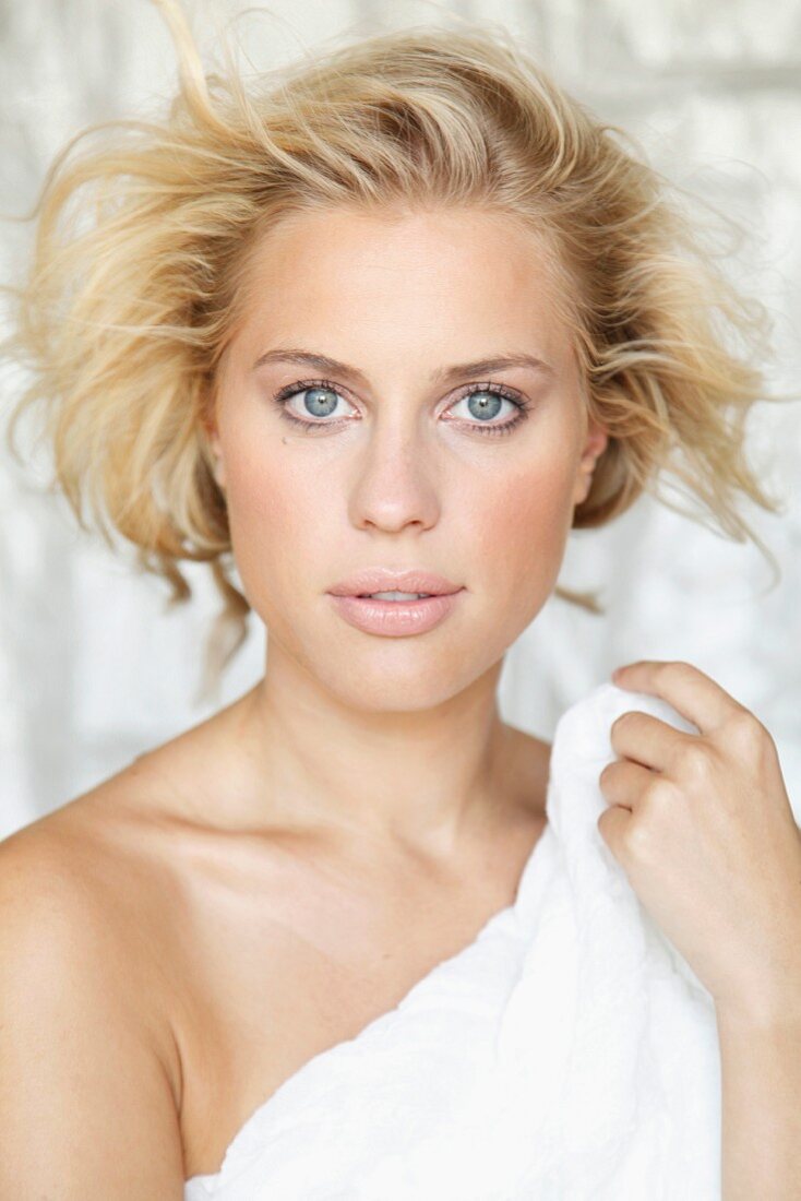 A young blonde woman wrapped in a towel