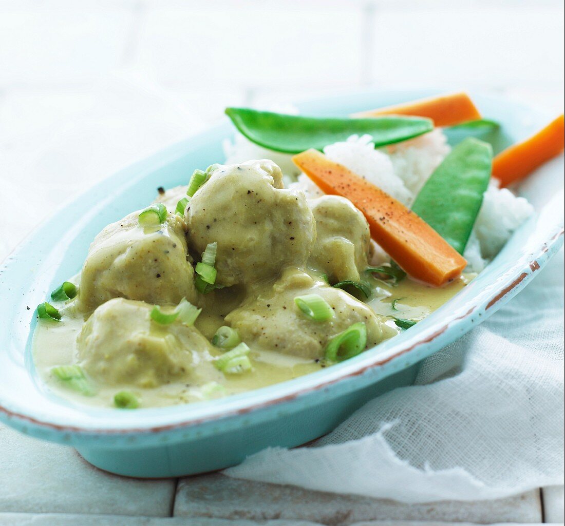 Meatballs in curry sauce with carrots, mange tout and rice