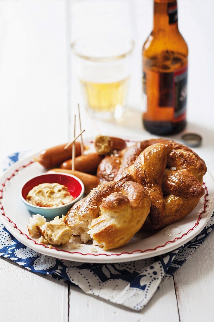 Lye bread pretzels with mini sausages and mustard