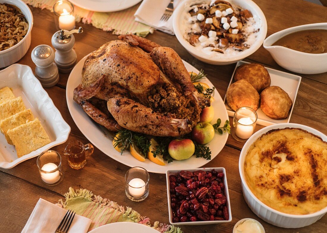A table laid with roast turkey and side dishes for Thanksgiving
