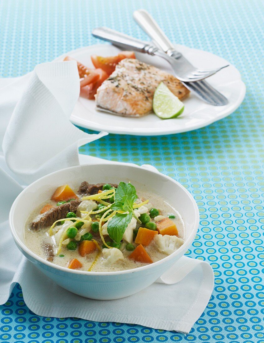 Coconut soup with beef, carrots and cauliflower served with baked salmon with tomatoes and lime