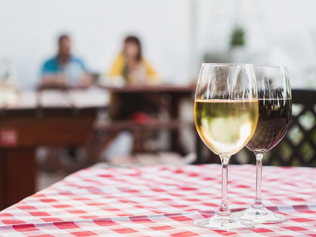 Weißwein und Rotwein aus Südafrika in Gläsern auf Restauranttisch
