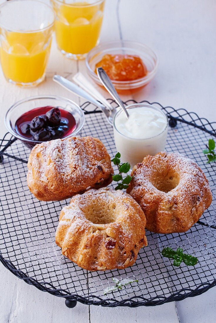 Mini Bundt cakes with icing sugar, cream and jam